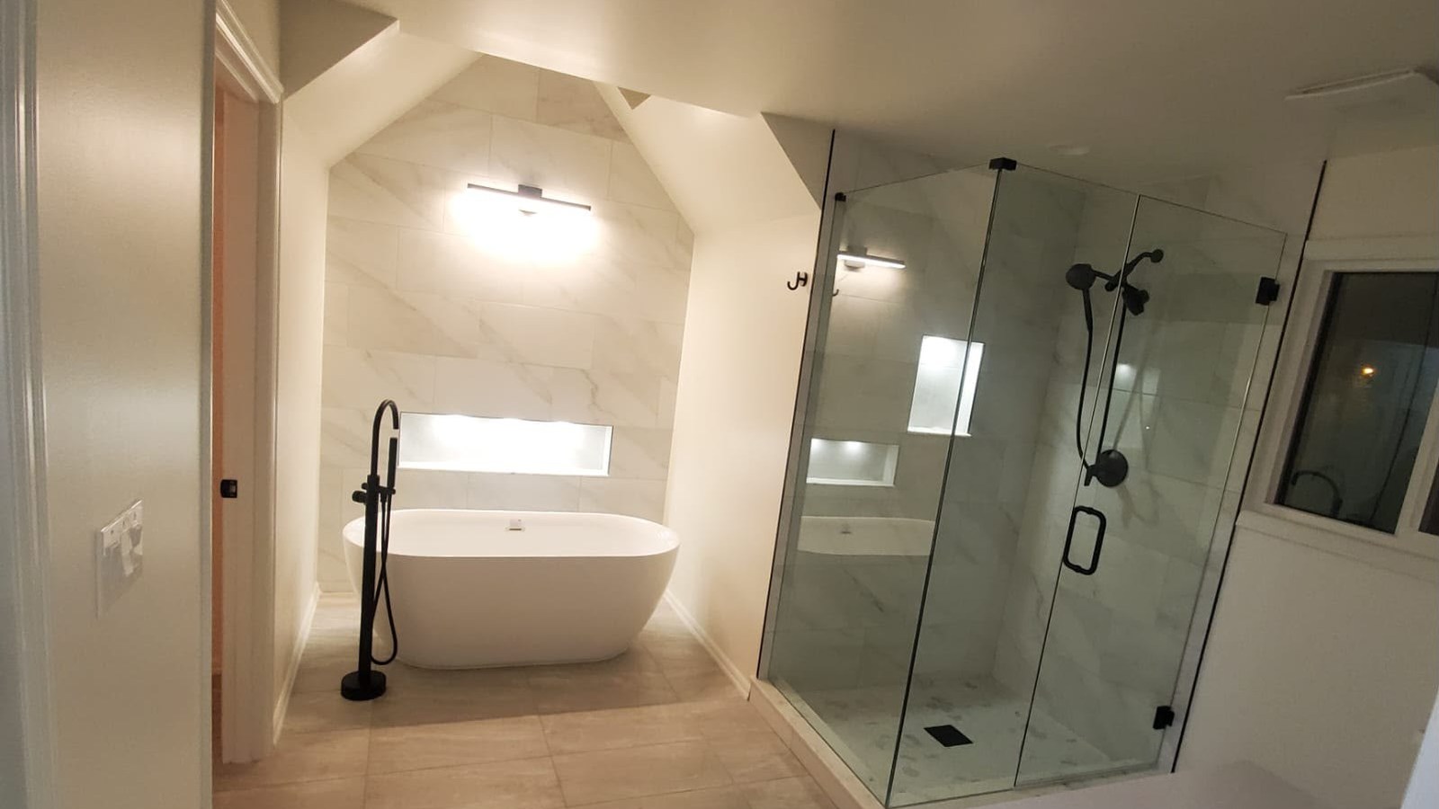 Bathroom with freestanding tub, marble feature wall and glass shower by Tile Palace LLC